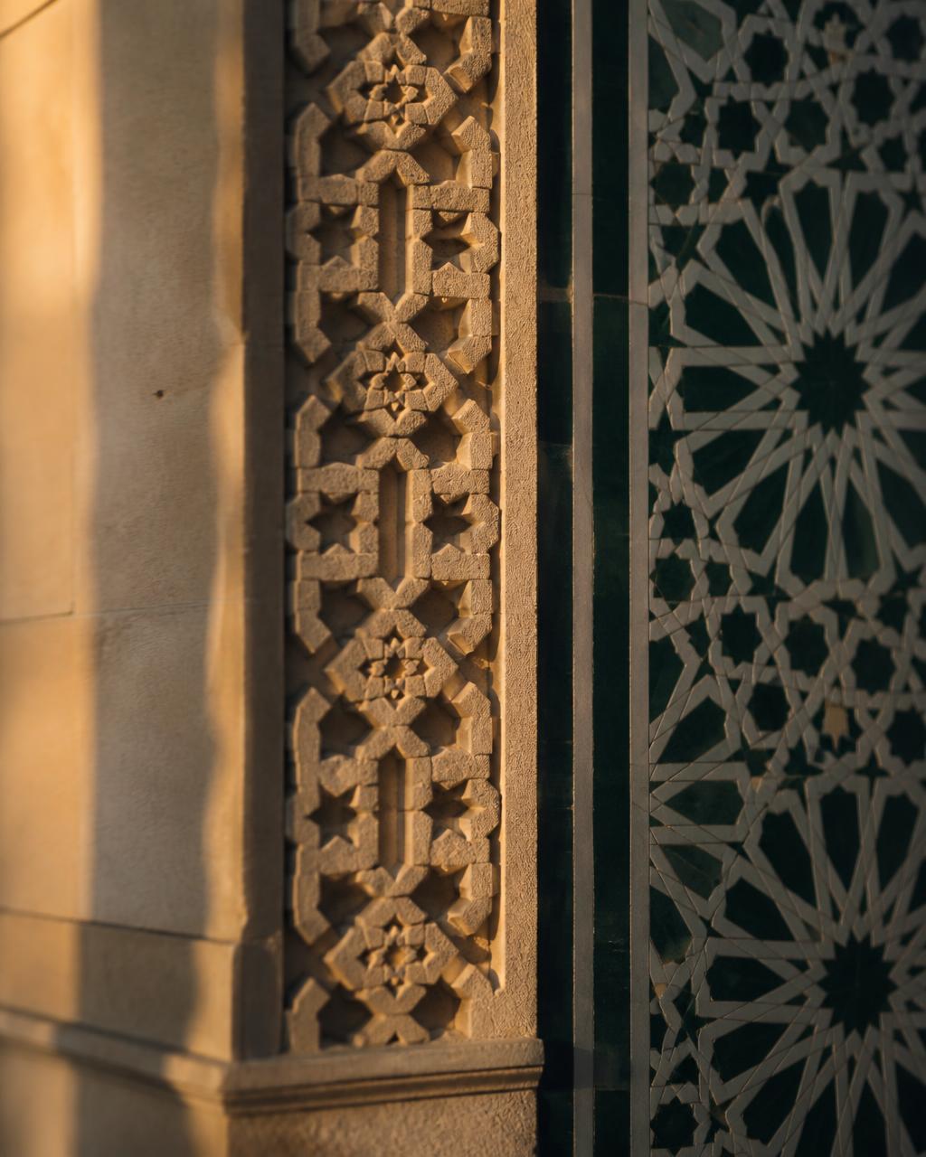 Carved Islamic geometric stonework in warm evening light